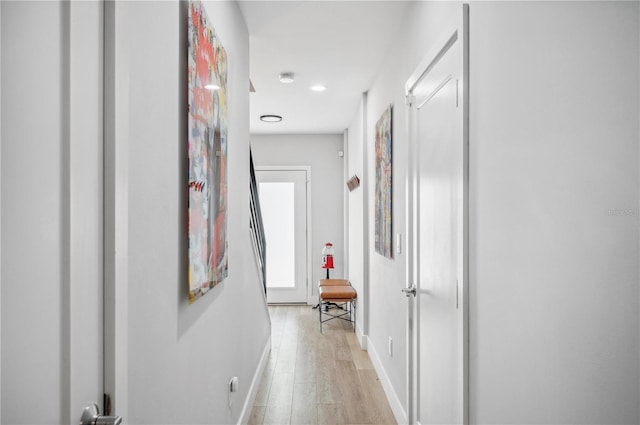 hallway with light wood finished floors and baseboards