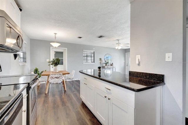 kitchen featuring visible vents, appliances with stainless steel finishes, dark wood-style flooring, a textured ceiling, and white cabinetry