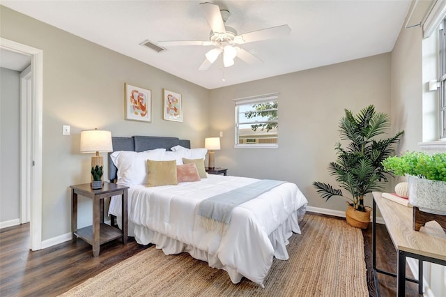 bedroom featuring a ceiling fan, visible vents, baseboards, and wood finished floors