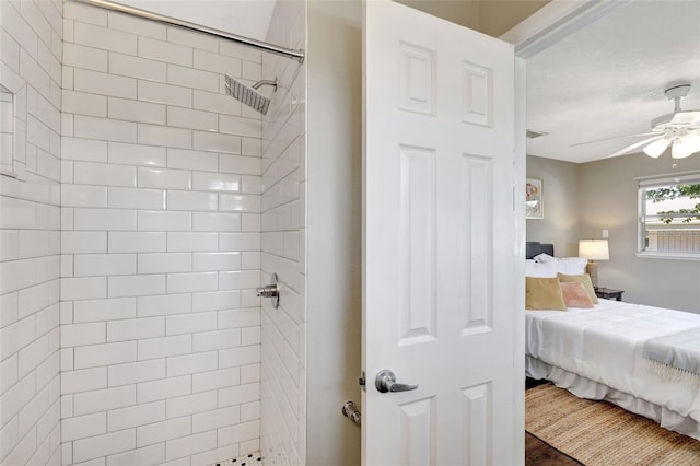 ensuite bathroom with tiled shower, connected bathroom, and a ceiling fan