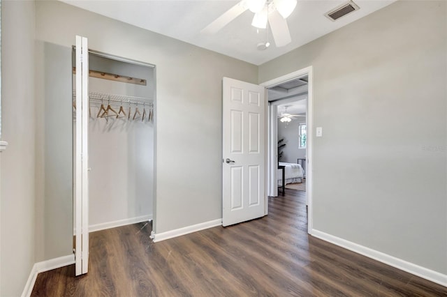 unfurnished bedroom featuring a closet, visible vents, a ceiling fan, wood finished floors, and baseboards