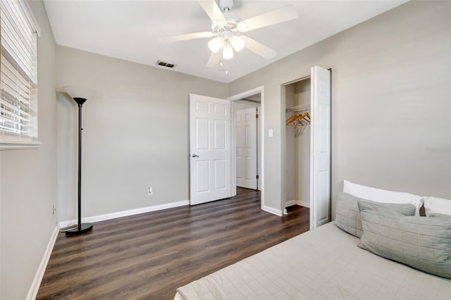 bedroom featuring visible vents, ceiling fan, baseboards, and wood finished floors