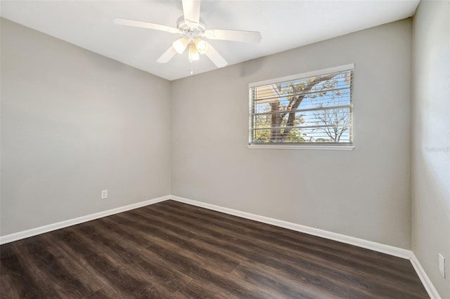 empty room featuring a ceiling fan, dark wood finished floors, and baseboards