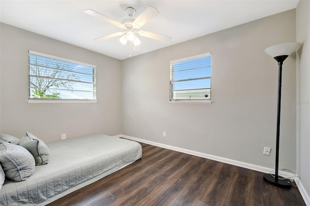 bedroom featuring multiple windows, baseboards, and dark wood-style flooring