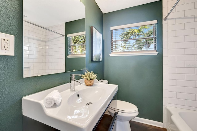 full bathroom featuring shower / bathing tub combination, toilet, vanity, wood finished floors, and baseboards