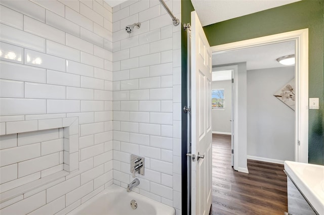 full bath featuring baseboards, wood finished floors, and shower / bathtub combination