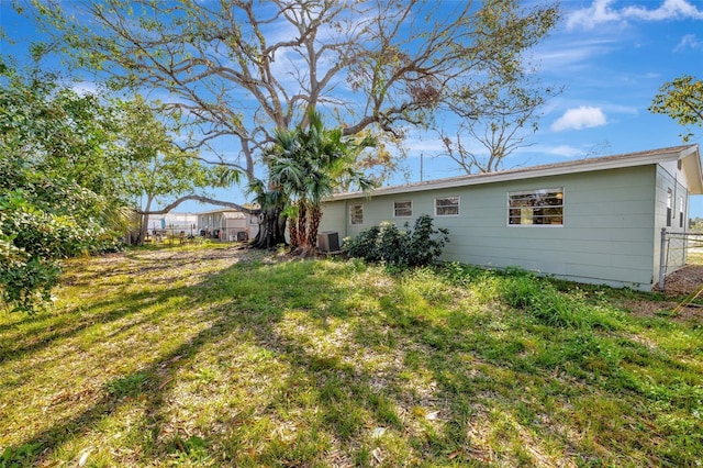 back of house with fence and central AC unit