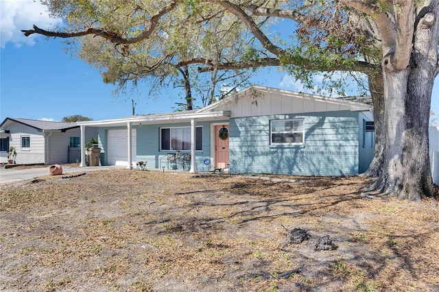 single story home featuring a garage, driveway, board and batten siding, and brick siding