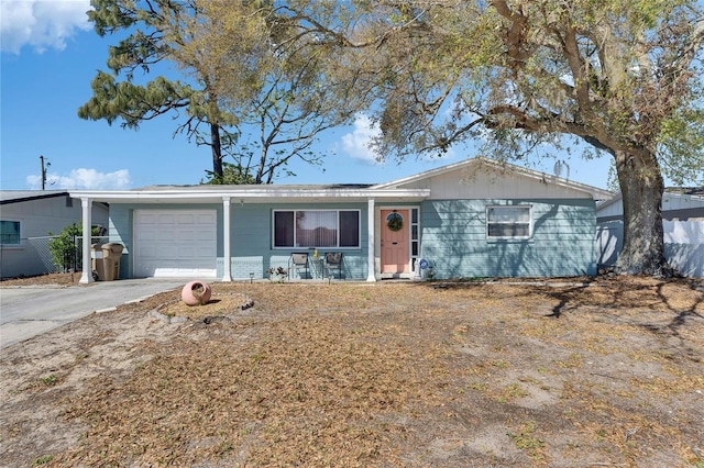 ranch-style home featuring a garage, driveway, and fence