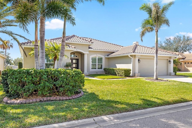 mediterranean / spanish home with stucco siding, a garage, a front yard, and a tiled roof