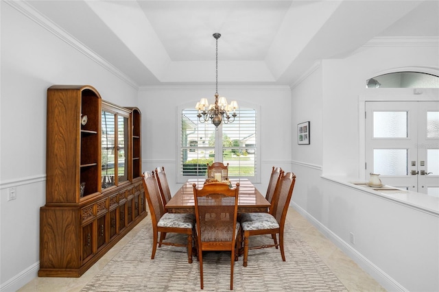 dining area featuring an inviting chandelier, plenty of natural light, baseboards, and a raised ceiling