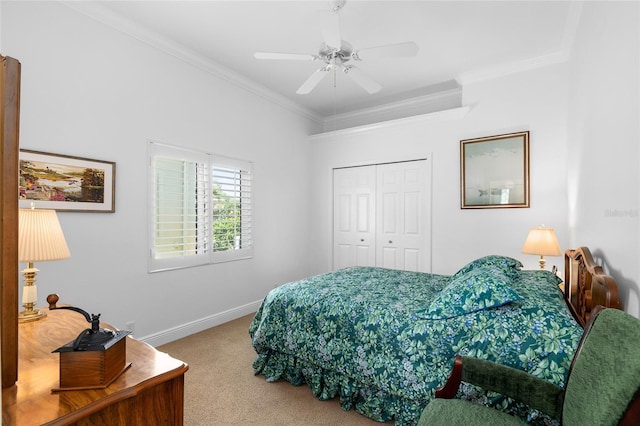 bedroom with a closet, carpet flooring, crown molding, and baseboards