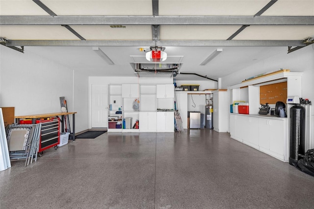 garage with electric water heater and a garage door opener