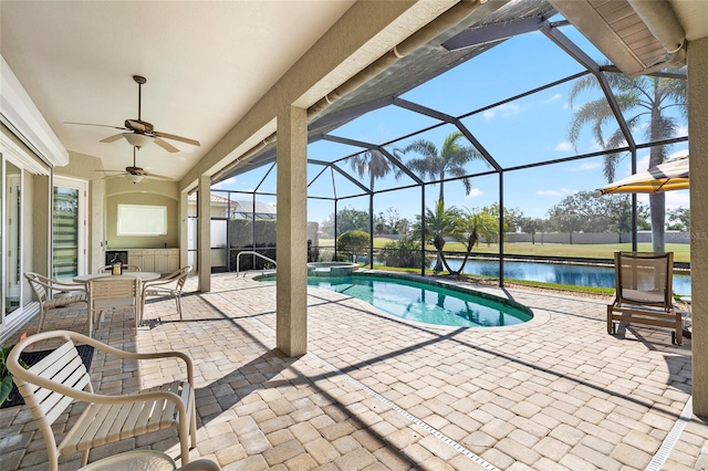 view of pool featuring a pool with connected hot tub, ceiling fan, a water view, a lanai, and a patio area