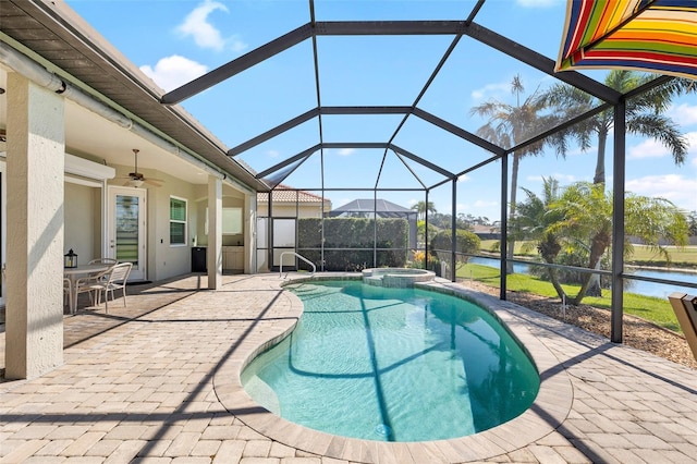 view of swimming pool with glass enclosure, a patio, a water view, and a pool with connected hot tub