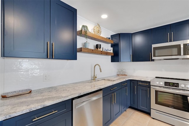 kitchen with stainless steel appliances, blue cabinets, a sink, and light tile patterned floors