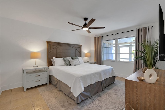 bedroom with ceiling fan, baseboards, and light tile patterned floors