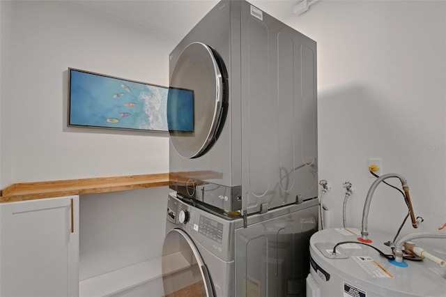 washroom featuring stacked washer and clothes dryer, water heater, and laundry area