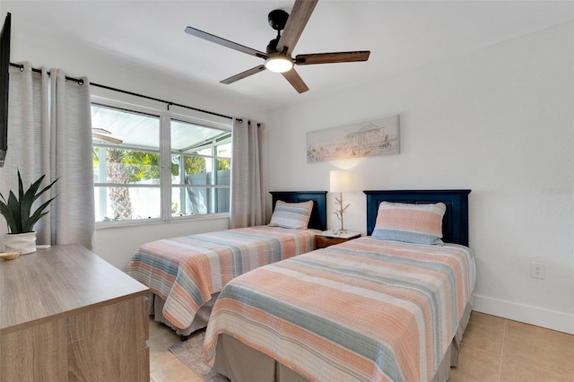 bedroom featuring light tile patterned floors, ceiling fan, and baseboards