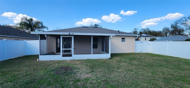 rear view of house with a yard, a fenced backyard, and a sunroom