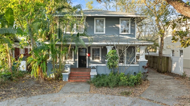 view of front of house featuring covered porch and fence