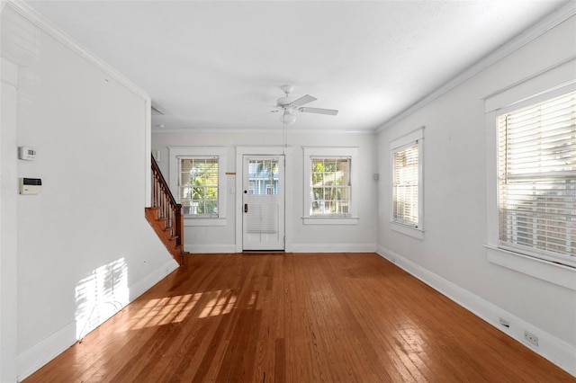 entryway featuring stairs, ornamental molding, wood-type flooring, and baseboards