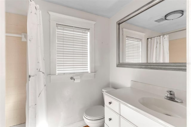 bathroom featuring a shower with shower curtain, vanity, and toilet