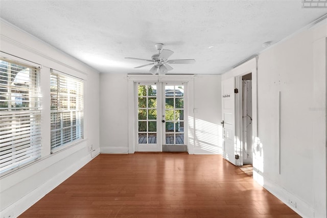 spare room with a ceiling fan, french doors, a textured ceiling, and wood finished floors