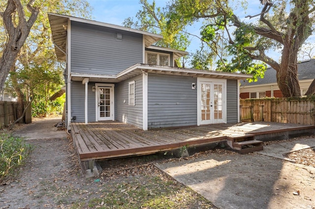 rear view of property with french doors, fence, and a wooden deck