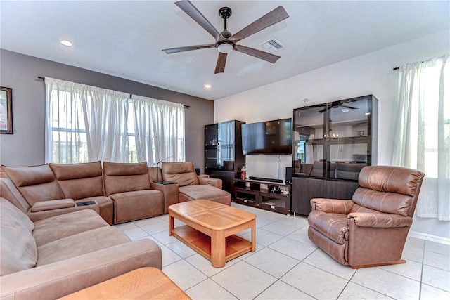 living area with light tile patterned flooring, a ceiling fan, and a wealth of natural light