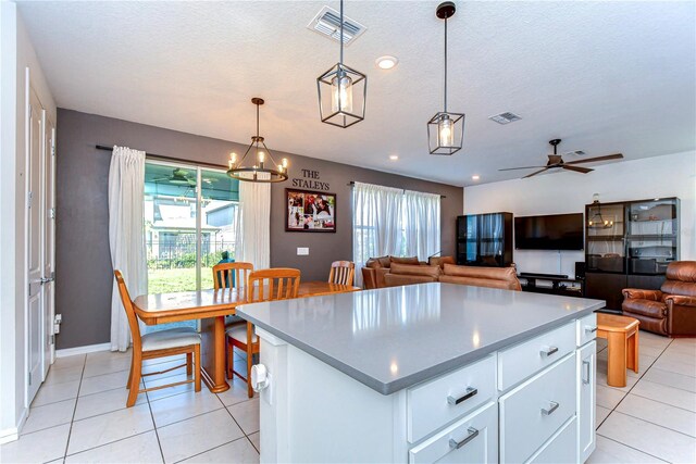 kitchen featuring white cabinetry, ceiling fan with notable chandelier, visible vents, and a textured ceiling