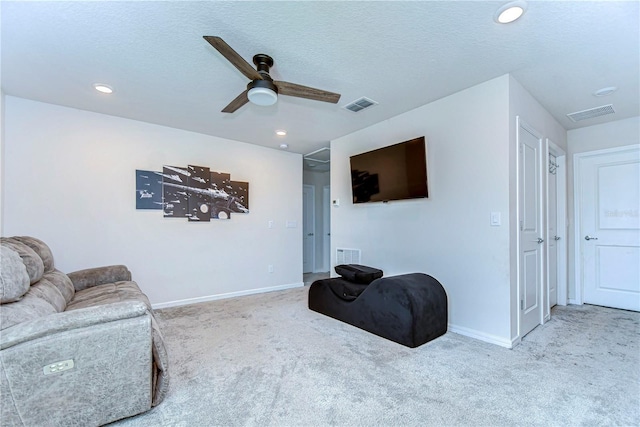 living area with visible vents, carpet floors, baseboards, and ceiling fan