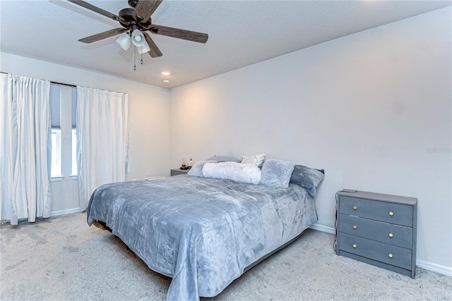 carpeted bedroom with baseboards and ceiling fan