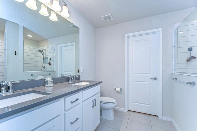 full bathroom with tile patterned flooring, visible vents, a tile shower, and a sink