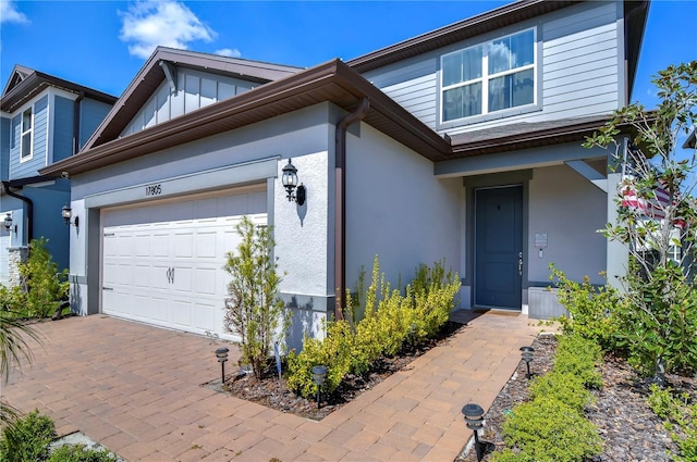 view of front facade with stucco siding, driveway, and a garage