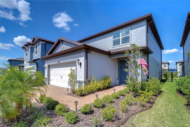 view of front facade with a garage, decorative driveway, and stucco siding