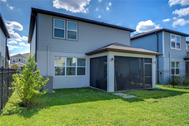 back of house featuring a fenced backyard, a lawn, and a sunroom