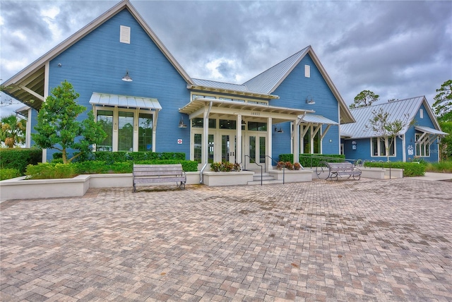 back of property with french doors, metal roof, and a standing seam roof