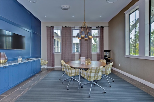 dining area featuring a notable chandelier, baseboards, and plenty of natural light