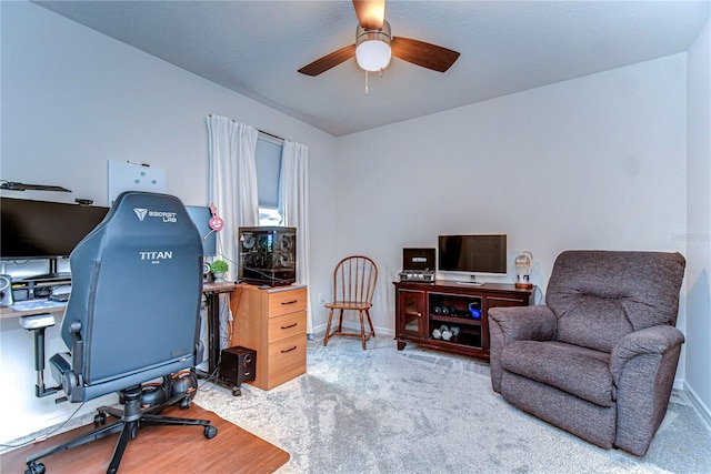 carpeted office with baseboards and a ceiling fan