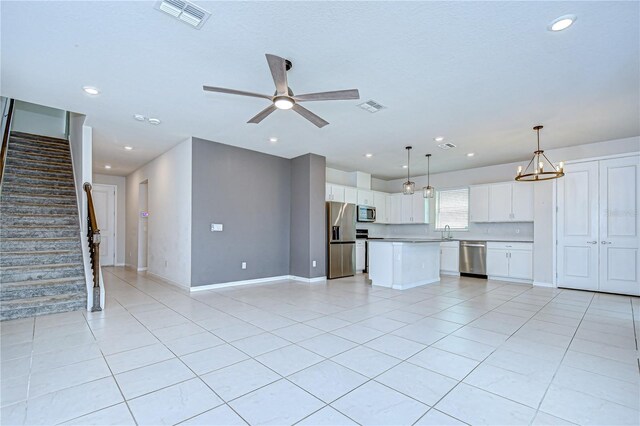 17805 Everlong Dr, Land O Lakes, FL 34638 - unfurnished living room featuring light tile patterned floors, stairway, ceiling fan, recessed lighting, and a chandelier