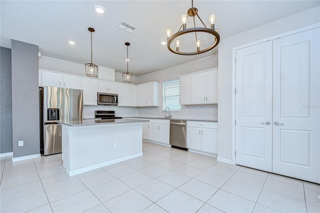 17805 Everlong Dr, Land O Lakes, FL 34638 - kitchen with stainless steel appliances, a chandelier, white cabinets, light tile patterned floors, and light countertops