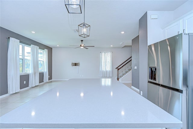 17805 Everlong Dr, Land O Lakes, FL 34638 - interior space with stainless steel refrigerator with ice dispenser, white cabinets, a ceiling fan, open floor plan, and hanging light fixtures