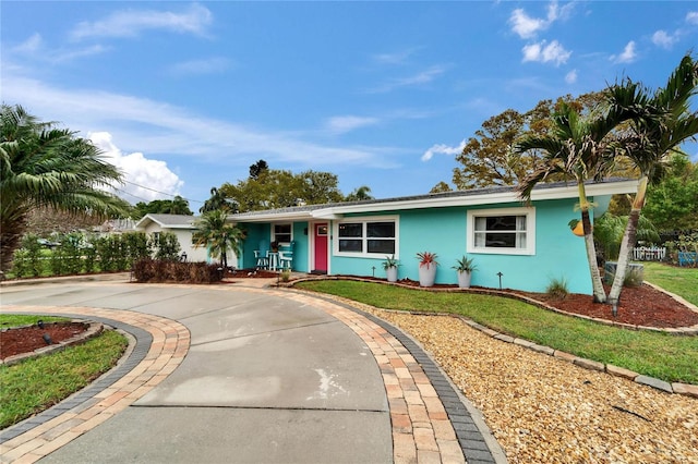 ranch-style home with stucco siding and a front lawn