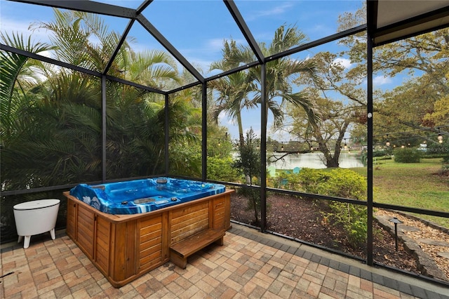 unfurnished sunroom with a jacuzzi and a water view