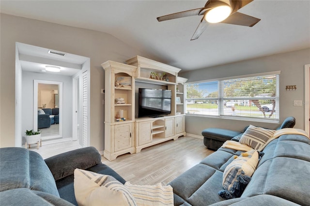 living room featuring light wood-type flooring, visible vents, lofted ceiling, baseboards, and ceiling fan