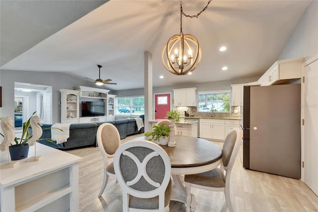 dining room featuring recessed lighting, light wood finished floors, ceiling fan with notable chandelier, and vaulted ceiling