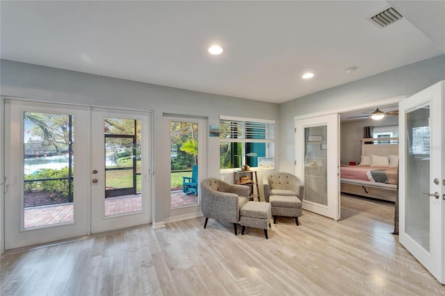 living area with visible vents, plenty of natural light, french doors, and light wood-style floors