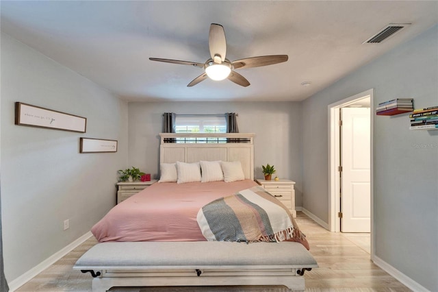 bedroom featuring a ceiling fan, baseboards, visible vents, and light wood-type flooring