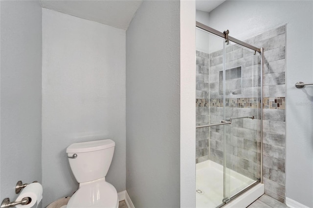 bathroom featuring toilet and a stall shower